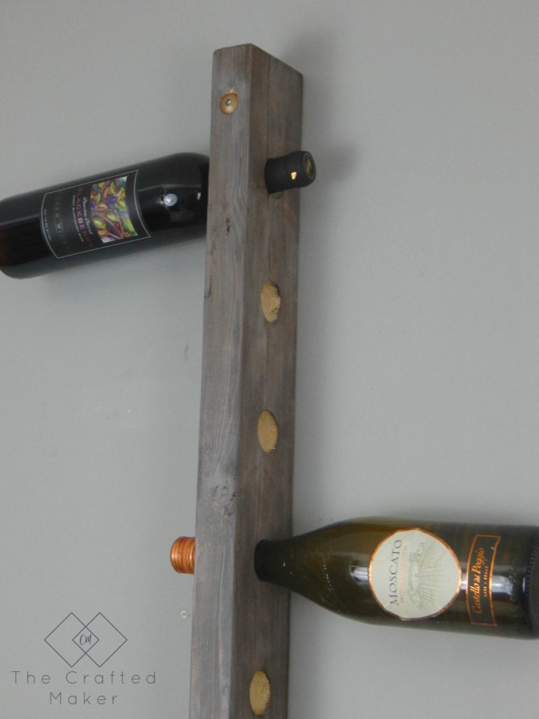 Build this DIY hanging wine rack out of one 2X4 board. For less than a bottle of wine, you can display your wine selection in style. 